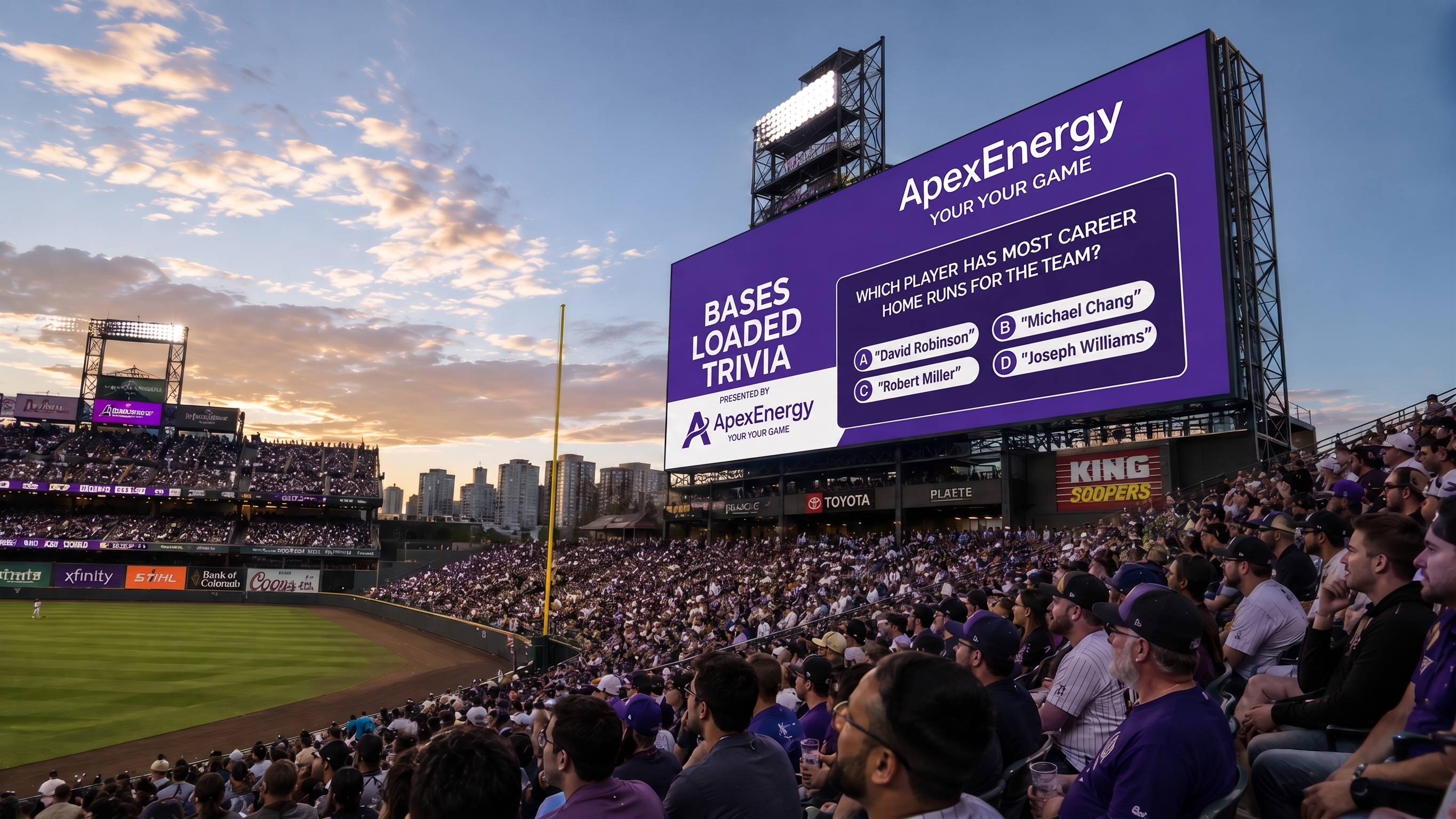 Panoramic view of a packed baseball stadium at sunset, with fans filling the stands and watching the field below. A large purple jumbotron dominates the scene, displaying an ApexEnergy “Bases Loaded Trivia” game with a multiple-choice question, while stadium lights, a foul pole, outfield signage, and a city skyline complete the realistic game-day atmosphere.