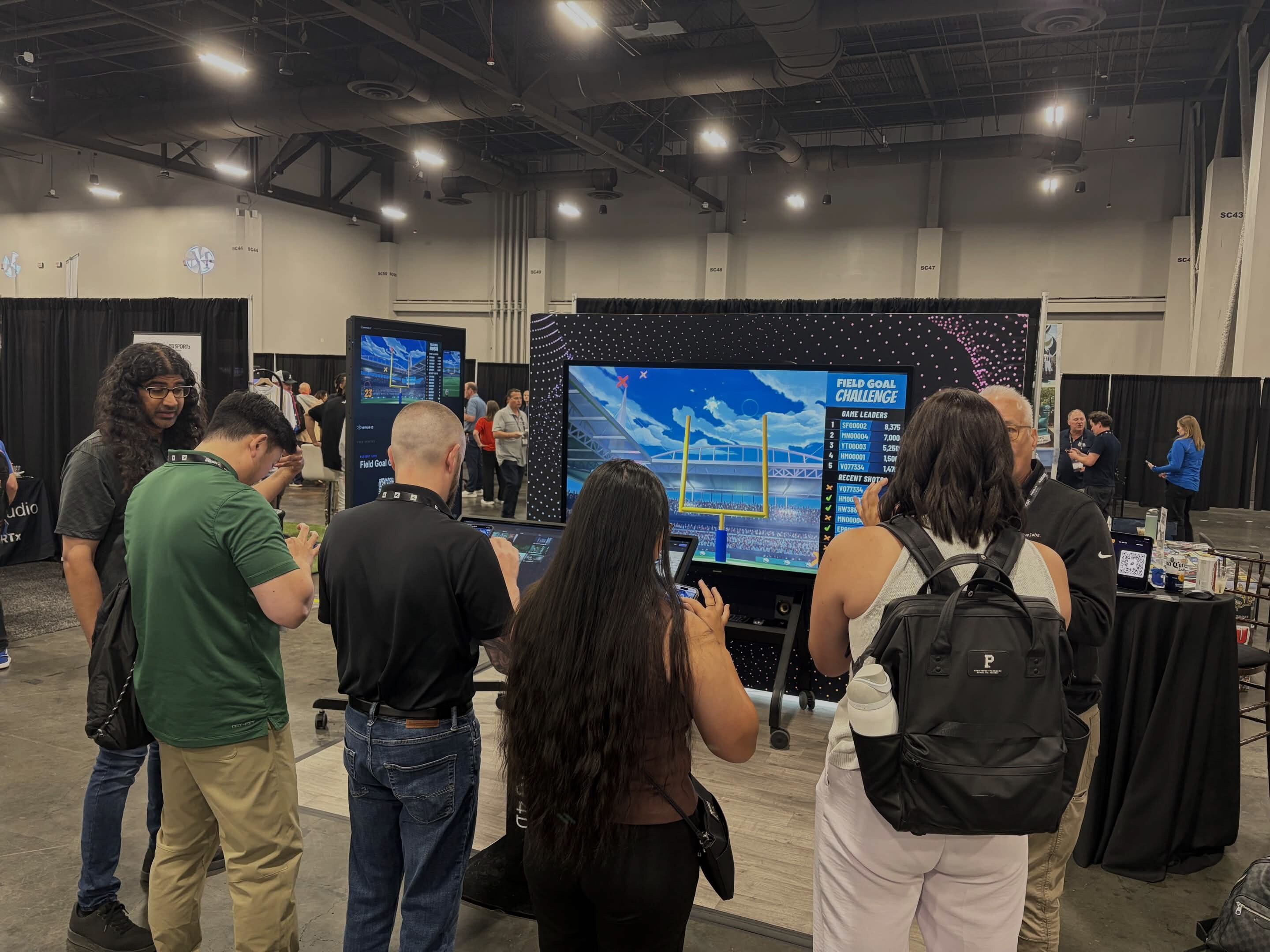 A group of people gathers around an interactive 
