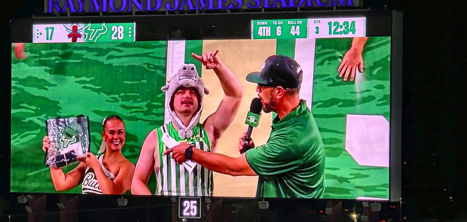 The host works the stands; fans appear live on the board